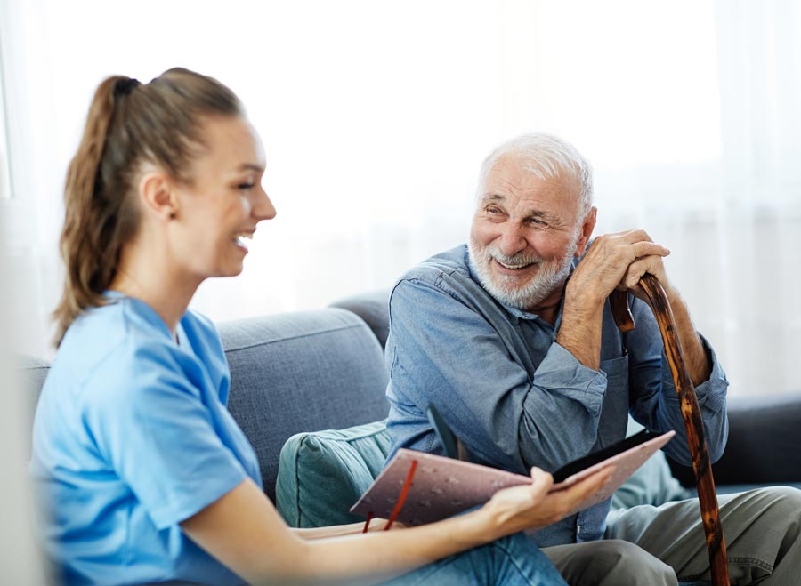 home care nurse talking with patient on couch