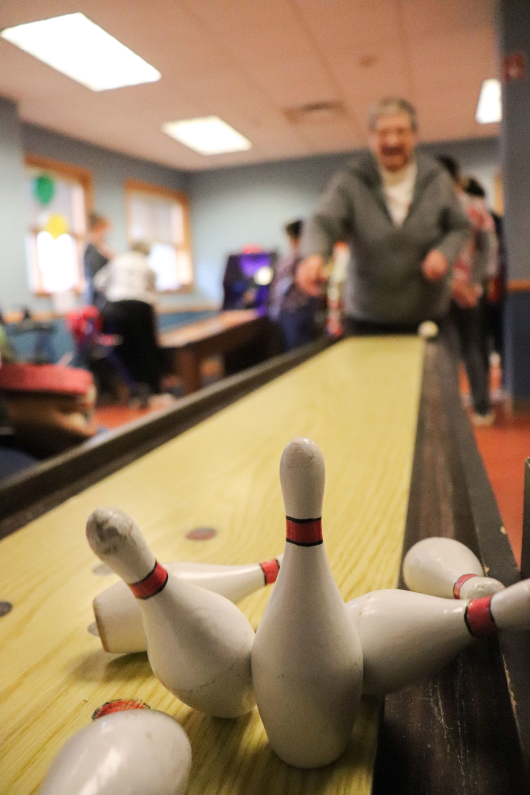 Image of falling bowling pins and unknown man, shot take Masonic Care Community Bowling center on 2nd floor