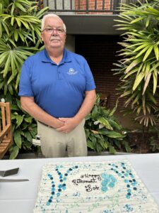 Bob Butler poses in front of his cake